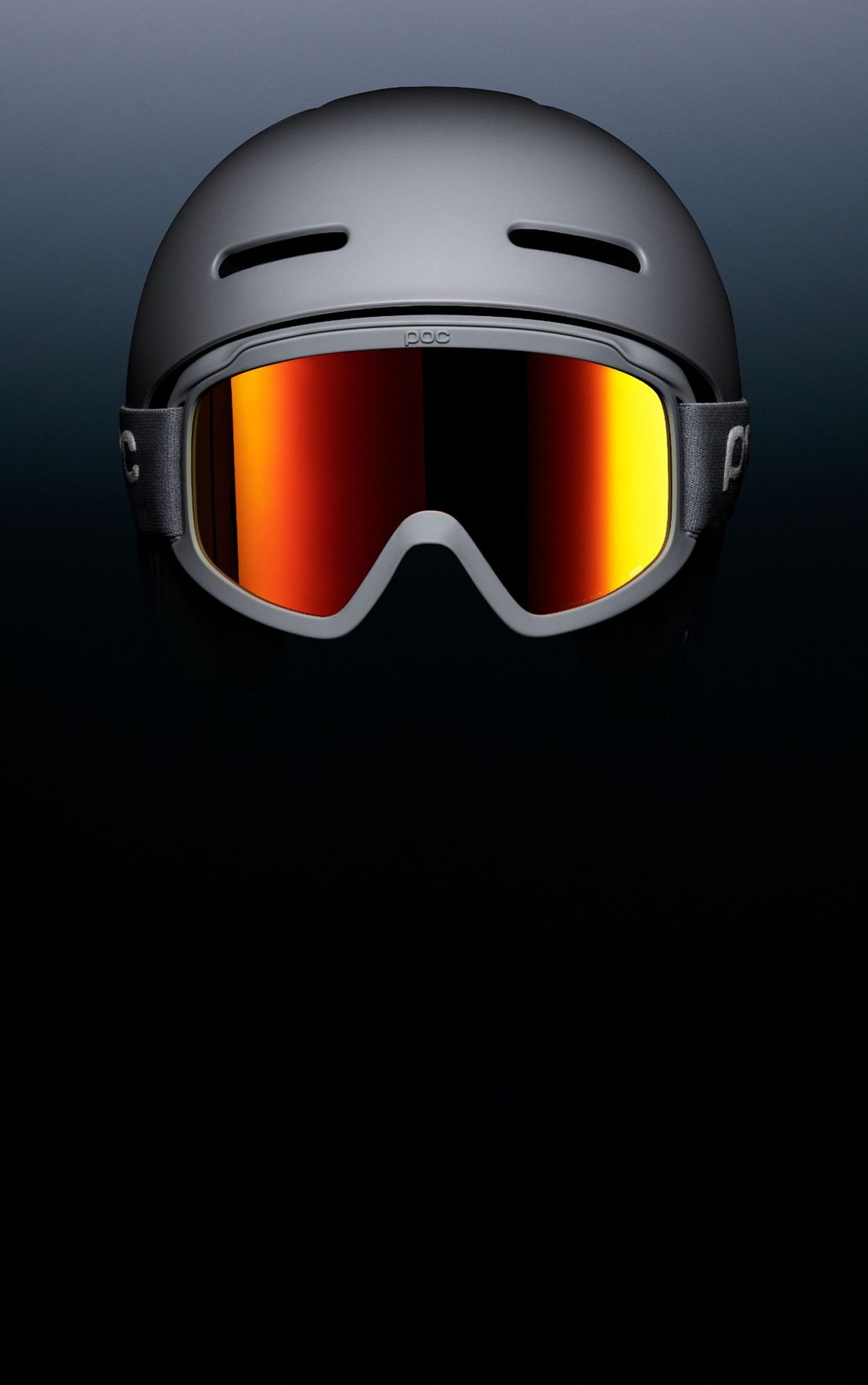 Grey ski helmet with integrated orange and yellow mirrored ski goggles against blue background